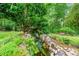 Lush landscaping including rock waterfall feature and mature trees offering shade and beauty at 312 Crabapple Springs Way, Woodstock, GA 30188