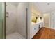 Bright bathroom featuring a glass enclosed shower, a double vanity, and wood flooring at 312 Crabapple Springs Way, Woodstock, GA 30188