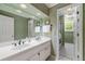 Bathroom with double vanity, large mirror, and access to bath with shower behind glass at 312 Crabapple Springs Way, Woodstock, GA 30188