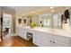 Bright bathroom with double vanity, white cabinets, a large mirror, and wood flooring at 312 Crabapple Springs Way, Woodstock, GA 30188
