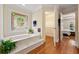 Spa-like bathroom with a jetted tub, stained glass window, walk in closet and wood floors at 312 Crabapple Springs Way, Woodstock, GA 30188