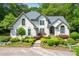 Elegant home featuring manicured landscaping and a charming facade, surrounded by mature trees at 312 Crabapple Springs Way, Woodstock, GA 30188