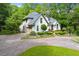 Stately home with manicured front lawn, lush landscaping, circular driveway, and elegant architectural details at 312 Crabapple Springs Way, Woodstock, GA 30188