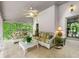 Bright sunroom with tile floors, ceiling fan, large windows, and comfortable seating at 312 Crabapple Springs Way, Woodstock, GA 30188