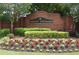 Landscaped entrance to Abberley Township with a brick sign and colorful flowers at 4875 Carre Way, Alpharetta, GA 30022