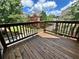 A spacious wooden deck with railing offers lovely views of surrounding community homes and lush greenery at 4875 Carre Way, Alpharetta, GA 30022