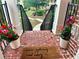 View of a front porch, with brick flooring, plants, and a welcome mat that says 'Hope you brought wine' at 4875 Carre Way, Alpharetta, GA 30022