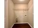 A view of the laundry room, featuring hardwood floors, utility connections, and a wire shelf for storage at 4875 Carre Way, Alpharetta, GA 30022