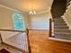 Light-filled living room boasting hardwood floors, chandelier, and staircase at 4875 Carre Way, Alpharetta, GA 30022