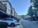 A street view featuring townhomes, with a line of parked cars along the curb at 4875 Carre Way, Alpharetta, GA 30022