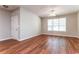 Bright living room with hardwood floors, ceiling fan, and a large window providing natural light at 112 Hawkeye Ln, Conyers, GA 30012
