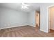 Spacious main bedroom with plush carpeting, a ceiling fan, and an en-suite bathroom at 112 Hawkeye Ln, Conyers, GA 30012