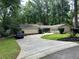 Charming home with manicured lawn, featuring a long driveway and attached garage at 2671 Club Forest Se Ct, Conyers, GA 30013