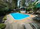 A backyard pool is surrounded by mature landscaping, seating, and privacy at 2671 Club Forest Se Ct, Conyers, GA 30013