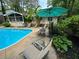 Lush landscaping surrounds a backyard pool, lounge seating, and umbrellas at 2671 Club Forest Se Ct, Conyers, GA 30013