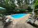 Enjoy this backyard pool with lounge seating, surrounded by lush landscaping at 2671 Club Forest Se Ct, Conyers, GA 30013