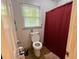 Small toilet room featuring a standard toilet and a red shower curtain for added privacy at 2671 Club Forest Se Ct, Conyers, GA 30013