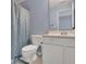 Bathroom with toilet, vanity, and tub/shower with a stylish blue shower curtain at 541 Lantern Wood Dr, Scottdale, GA 30079
