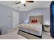 Comfortable bedroom with a cushioned headboard and large window with blue curtains at 541 Lantern Wood Dr, Scottdale, GA 30079