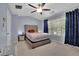 Comfortable bedroom with a large window, blue curtains, and a cushioned headboard at 541 Lantern Wood Dr, Scottdale, GA 30079