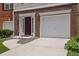 Exterior of townhome with brick facade, driveway, front door, and attached one car garage at 541 Lantern Wood Dr, Scottdale, GA 30079