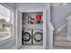 Laundry room features a modern washer and dryer, shelving, and natural light at 541 Lantern Wood Dr, Scottdale, GA 30079