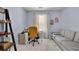 This home office is styled with a comfortable couch, shelves, and a contemporary desk with a yellow desk chair at 541 Lantern Wood Dr, Scottdale, GA 30079