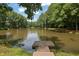 Wooden dock overlooking a peaceful community pond, surrounded by lush greenery and trees at 541 Lantern Wood Dr, Scottdale, GA 30079