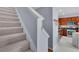 Carpeted stairs with white trim next to a kitchen area at 541 Lantern Wood Dr, Scottdale, GA 30079