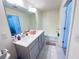 Bathroom with double sinks, grey cabinets, a bathtub, and neutral-toned flooring, well illuminated at 82 Auburn Run Ln, Auburn, GA 30011