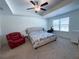 Bright main bedroom with a ceiling fan, carpet flooring, and large window providing natural light at 82 Auburn Run Ln, Auburn, GA 30011
