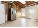 Unfinished basement area with concrete floor, utility connections and stainless refrigerator at 2280 Wildwood Lake Dr, Suwanee, GA 30024