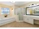 Bright bathroom with tub, shower, and vanity featuring a framed mirror and vanity lights at 2280 Wildwood Lake Dr, Suwanee, GA 30024