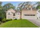 Elegant two-story home showcasing lush front lawn, attached two car garage, and well-maintained landscaping at 2280 Wildwood Lake Dr, Suwanee, GA 30024