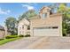 Stately home featuring a two-car garage, manicured lawn, complemented by mature trees and attractive facade at 2280 Wildwood Lake Dr, Suwanee, GA 30024