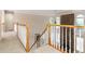 Open hallway with white railings overlooks a living space with tall windows and a stone fireplace at 2280 Wildwood Lake Dr, Suwanee, GA 30024