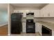 A kitchen featuring white cabinets, black appliances and granite-style countertops at 4345 Kimball Sw Rd, Atlanta, GA 30331