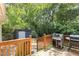 A split-level backyard featuring a deck with barbecue grills and a storage shed surrounded by lush greenery at 4648 Equestrian Way, Atlanta, GA 30338