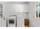 Clean laundry room featuring a washer, a dryer, a window, and white cabinets for storage at 4648 Equestrian Way, Atlanta, GA 30338