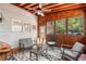 Comfortable sunroom with wood paneled walls, ceiling fan, and stylish furniture set against a patterned rug at 4648 Equestrian Way, Atlanta, GA 30338