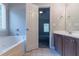 Bright bathroom featuring a soaking tub, vanity with sink, and an open doorway to bedroom at 4695 Ravenwood Loop, Union City, GA 30291