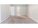 A bright, carpeted bedroom featuring neutral walls and an entry door at 4695 Ravenwood Loop, Union City, GA 30291