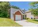 Lovely home with a well-maintained lawn, attached garage, and charming architectural details at 4695 Ravenwood Loop, Union City, GA 30291