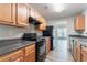 Well-lit kitchen with wood cabinets, modern black appliances, and gray countertops at 4695 Ravenwood Loop, Union City, GA 30291
