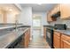 Bright kitchen showcasing stainless steel sink, wood cabinets, and black appliances at 4695 Ravenwood Loop, Union City, GA 30291