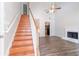 Bright living area with hardwood floors, fireplace, ceiling fan, and staircase at 4695 Ravenwood Loop, Union City, GA 30291