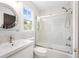 Bright bathroom with a glass-enclosed tub, a round mirror, and a white sink vanity at 4770 Powers Park Ne Ct, Marietta, GA 30067