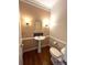 Powder room with pedestal sink, decorative mirror, and hardwood floors at 4770 Powers Park Ne Ct, Marietta, GA 30067