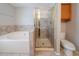 Bright bathroom with a shower, a jacuzzi, and tiled walls at 6509 Charter Way, Lithonia, GA 30058