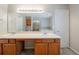 Bathroom with wooden cabinets, double sinks, and a large mirror at 6509 Charter Way, Lithonia, GA 30058